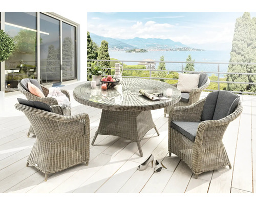 Terrasse mit Esstisch, Rattansesseln und Blick auf einen See