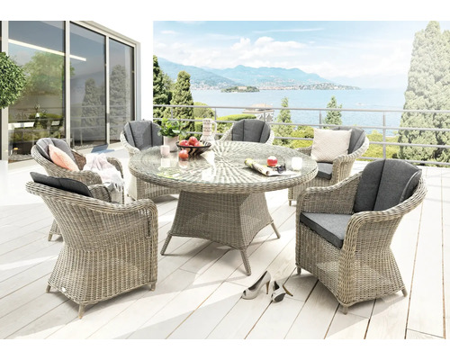 Gartenmöbel-Set mit rundem Tisch und Korbsesseln auf einer Terrasse mit Seeblick