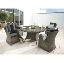 Gartenszene mit rundem Esstisch und vier Korbsesseln im Außenbereich