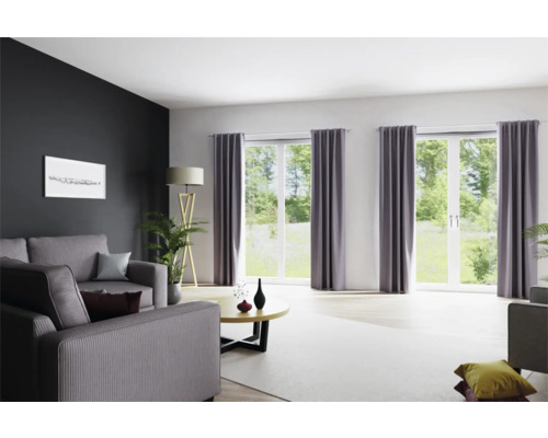 Wohnzimmer mit Sofa, Fenstern mit Vorhängen und Stehlampe