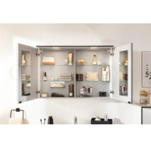 Geöffneter Spiegelschrank mit Glasablagen und Badartikeln