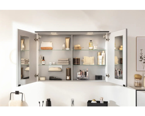 Geöffneter Spiegelschrank mit Glasablagen und Badartikeln