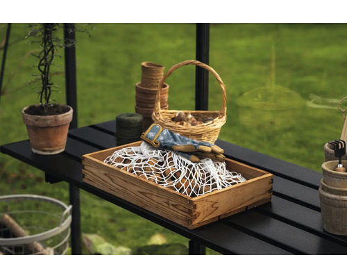 Gartenarbeitsszene mit Holzkiste, Gartenhandschuhen, Pflanzkörben und Gartengeräten auf einem Tisch