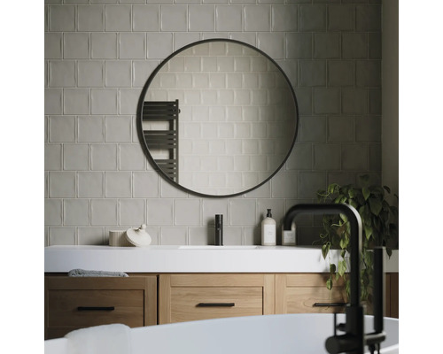 Modernes Badezimmer mit Waschtisch, rundem Spiegel und Fliesen