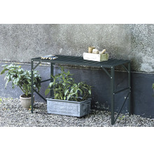 Gartentisch mit Pflanzen, Gartenwerkzeugen und Handschuhen im Außenbereich