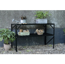 Gartentisch mit zwei Ablageflächen und Gartenzubehör wie Gießkanne und Pflanzen