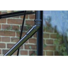 Detailaufnahme eines schwarzen Metallrohrs mit Verbindungselementen an einem Gewächshaus.