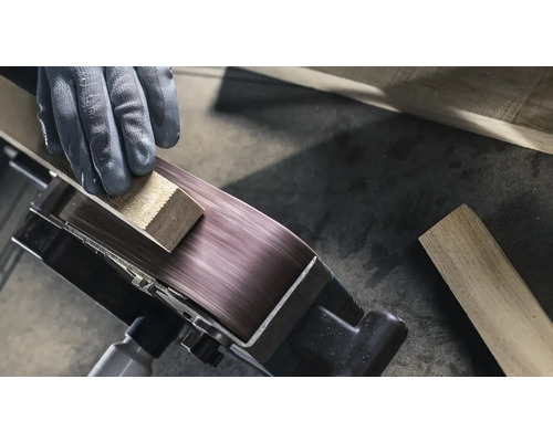 Nahaufnahme eines Bandschleifers mit Werkstückbearbeitung