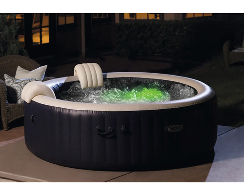 Aufblasbarer Whirlpool mit Kopfstützen und farbig beleuchtetem Wasser im Garten.