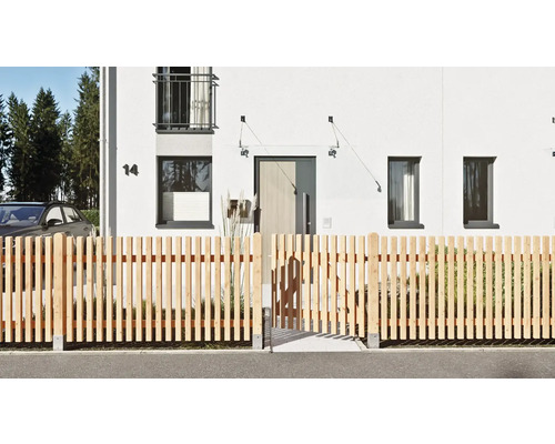 Moderner Staketenzaun aus hellem Naturholz mit integriertem Gartentor vor einem weißen Wohnhaus.