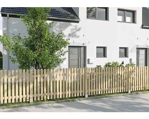 Hölzerner Lattenzaun mit Rundkopf vor einem modernen weißen Haus, Garten mit Baum und Sträuchern.