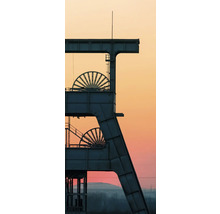 Silhouette eines Fördergerüsts einer Zeche mit zwei Seilscheiben vor einem Abendhimmel im Ruhrgebiet.