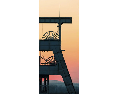 Silhouette eines Fördergerüsts einer Zeche mit zwei Seilscheiben vor einem Abendhimmel im Ruhrgebiet.