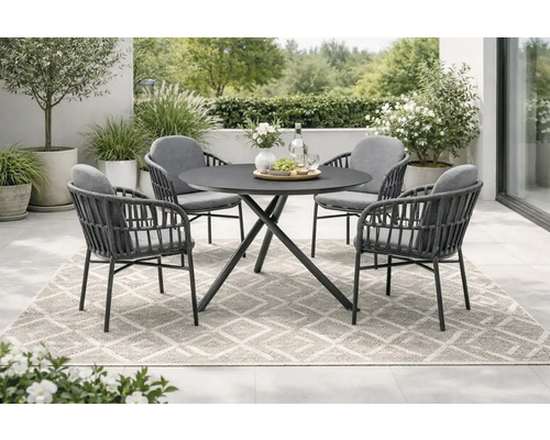 Gartenszene mit einem runden Tisch und vier Stühlen auf einem gemusterten Teppich