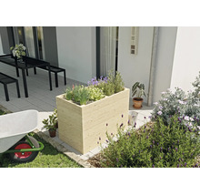 Rechteckiges Hochbeet aus hellem Holz mit horizontaler Lattung, bepflanzt mit Kräutern auf einer modernen Terrasse neben einer Sitzgruppe.