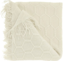 Gewebte Wohndecke mit hexagonalem Wabenmuster und Fransen.