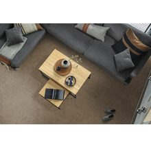 Strukturierte Bodenfliesen in Steinoptik im hellen Wohnzimmer mit grauem Sofa, hölzernen Couchtischen und dekorativen Kissen.