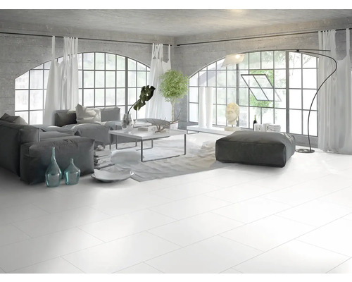 Modernes Wohnzimmer im Industriestil mit großen weißen Bodenfliesen, grauen Polstermöbeln und großen Rundbogenfenstern.