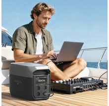 Mann auf einem Boot nutzt Laptop und Mischpult, angeschlossen an eine tragbare EcoFlow Powerstation auf einem hellen Holzdeck.