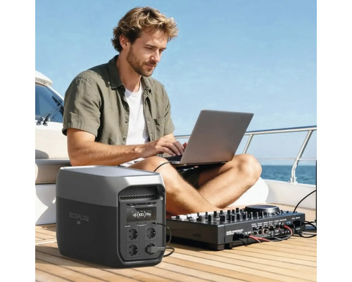 Mann auf einem Boot nutzt Laptop und Mischpult, angeschlossen an eine tragbare EcoFlow Powerstation auf einem hellen Holzdeck.