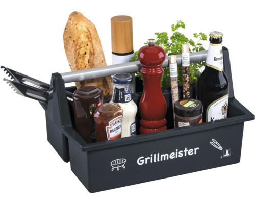 Schwarze Grillbox Grillmeister aus Kunststoff mit Metallgriff, gefüllt mit Grillzubehör, Grillsaucen, Gewürzmühlen, Kräutern, Baguette und Bier.