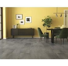 Großformatige Bodenfliesen in Betonoptik in einem hellen Esszimmer mit Sideboard, Esstisch und Zimmerpflanze.