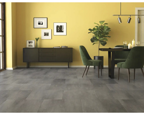 Großformatige Bodenfliesen in Betonoptik in einem hellen Esszimmer mit Sideboard, Esstisch und Zimmerpflanze.