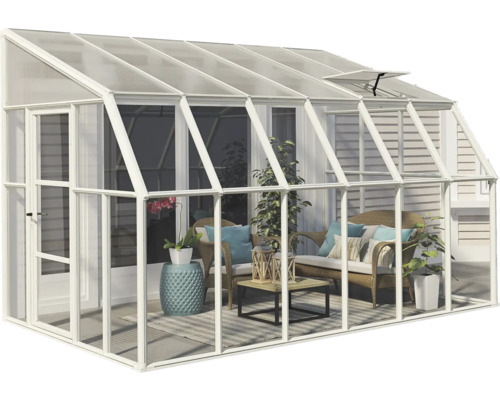 Anlehngewächshaus aus weißem Aluminium mit transparenten Scheiben, eingerichtet als heller Wintergarten mit Korbmöbeln, Pflanzen und Teppich.