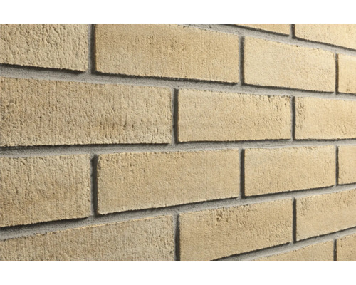 Beige Verblendsteine in Ziegeloptik mit rauer Oberfläche und grauen Fugen.