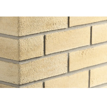 Strukturierte Mauer aus Kalksandstein mit Mörtelfugen an einer Wandecke.