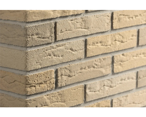 Beige Verblender in Steinoptik mit rauer Oberflächenstruktur an einer Wandecke.