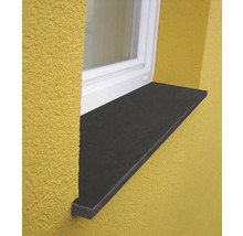 Außenfensterbank aus dunklem Stein unter einem weißen Fensterrahmen an einer verputzten Fassade.