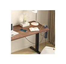 Schreibtisch Steckdosenleiste mit USB Ports an einem Holztisch in einem hellen organisierten Arbeitszimmer mit Laptop und Lampe.