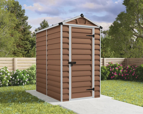 Ein Garten-Gerätehaus mit Satteldach und einer Tür auf einem Betonfundament in einem gepflegten Garten mit Blumen und Zaun.