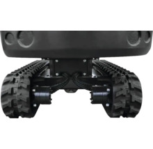 Detailansicht des Fahrwerks eines Minibaggers mit schwarzen Gummiketten, hydraulischen Fahrmotoren und verstärktem Metallrahmen.