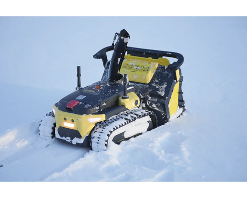 Autonome Schneefräse auf Raupenketten im Einsatz im Schnee.