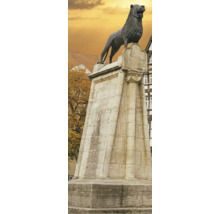 Braunschweiger Löwe Bronzestatue auf einem hohen Steinsockel vor historischer Kulisse mit herbstlichen Bäumen.