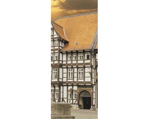 Historisches Fachwerkhaus mit dunklen Holzbalken, weißen Gefachen und einem Dach aus orangefarbenen Tondachziegeln.