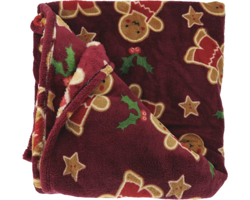 Kuscheldecke aus weichem Plüsch mit weihnachtlichen Motiven wie Lebkuchenmännchen, Sternen und Stechpalmen.