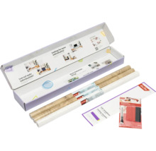 d-c-fix Set mit zwei Rollen Klebefolie in Holzoptik, einer weißen Rolle, Falt-Schablone, Rakel und Cutter in einer geöffneten Verpackung.