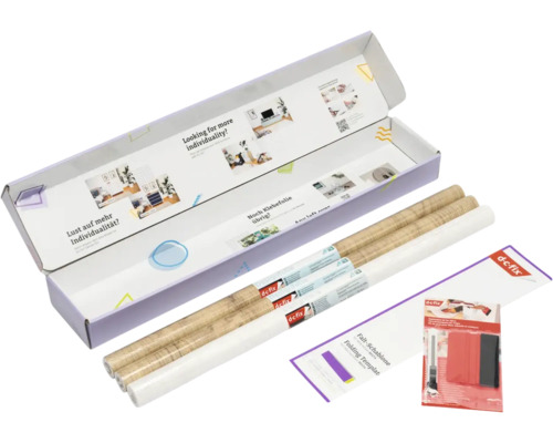 d-c-fix Set mit zwei Rollen Klebefolie in Holzoptik, einer weißen Rolle, Falt-Schablone, Rakel und Cutter in einer geöffneten Verpackung.