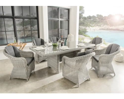Modernes Gartenmöbel-Set aus hellem Geflecht mit Glas-Esstisch und sechs Sesseln inklusive grauer Auflagen auf einer hellen, organisierten Terrasse.