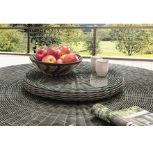 Runder Gartentisch aus grauem Polyrattan-Geflecht mit Glasplatte, darauf eine Obstschale und Tassen auf einer Terrasse mit Geländer und Naturblick.