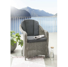 Geflochtener Gartenstuhl mit grauen Sitz- und Rückenpolstern auf einem hellen Balkon mit Aussicht auf See und Berge.