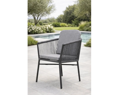 Moderner Garten-Armlehnstuhl mit Seilbespannung und grauen Polstern auf einer hellen Terrasse am Pool.