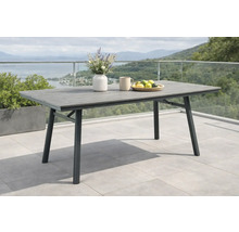 Rechteckiger Gartentisch mit grauer Tischplatte in Holzoptik und schwarzem Metallgestell auf einer hellen, geräumigen Terrasse.