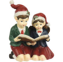 Weihnachtsfigur Junge und Mädchen beim gemeinsamen Lesen in einem Buch, beide tragen Weihnachtsmützen.