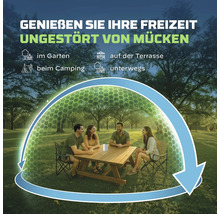 Helle Parkszene mit Personen an einem Holztisch. Ein Mückenschutzgerät erzeugt eine schützende Zone. Ideal für Garten, Terrasse und Camping.