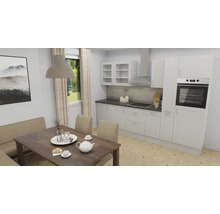 Moderne Einbauküche in Weiß mit Elektrogeräten und angrenzendem Essbereich mit Holztisch und Polsterbank.
