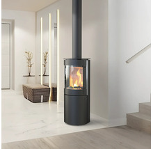 Moderner, zylindrischer Kaminofen aus schwarzem Stahl mit brennendem Feuer in einem hellen, minimalistischen Wohnraum.